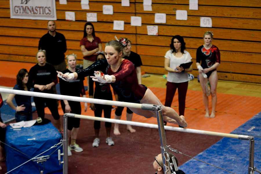 Senior Courtney Benson performs a mount on the uneven bars. She won the NCGA Outstanding Senior Athlete Award to 	end  on a high note.