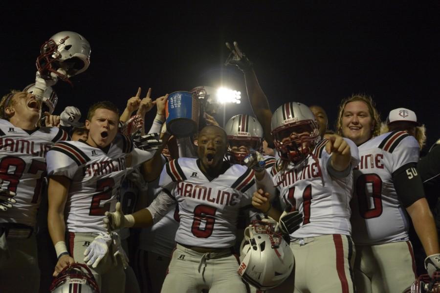 Piper football players celebrate with The Bucket after their 27-10 win over Macalester on Sep. 12.