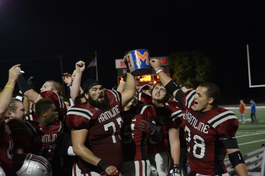 Piper football players celebrate after they win the battle for the Paint Bucket in the 2014 season. The Pipers won the bucket back after a multi-year hiatus. The Paint Bucket will stay with Hamline for another after the team beat the Scots, 27-10 on Sep. 12.