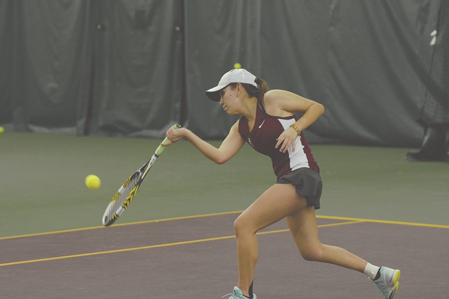 Senior Emily Butler hits a forehand in an indoor match during the 2014-15 season.