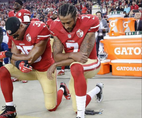 Quarterback Colin Kaepernick kneels with teammate Eric Reid before their Monday Night Football game against the Rams.