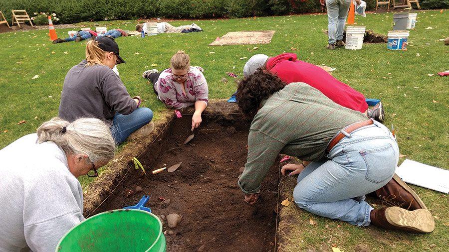 Students and community members dig at one of three sites near Bush Memorial Library.