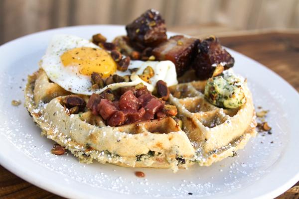 The Savory Waffle from Birchwood Cafe with a wild rice, kale, and fontina waffle topped with a cranberry pear chutney, pistachio parsley butter, bacon lardoons, and a sunny-side up egg. Available all day, every day! 