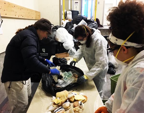 Environmental Studies Professor Valentine Cadieux, junior Jenni Abere and first-year Kennedy Simpson sort trash coming from Starbucks on Friday, Dec. 2. Approximately 10 full sandwiches were collected and sorted into the compostables from this bag. 
