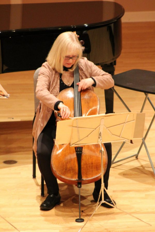 Janet Horvath plays the cello during key moments of the presentation.