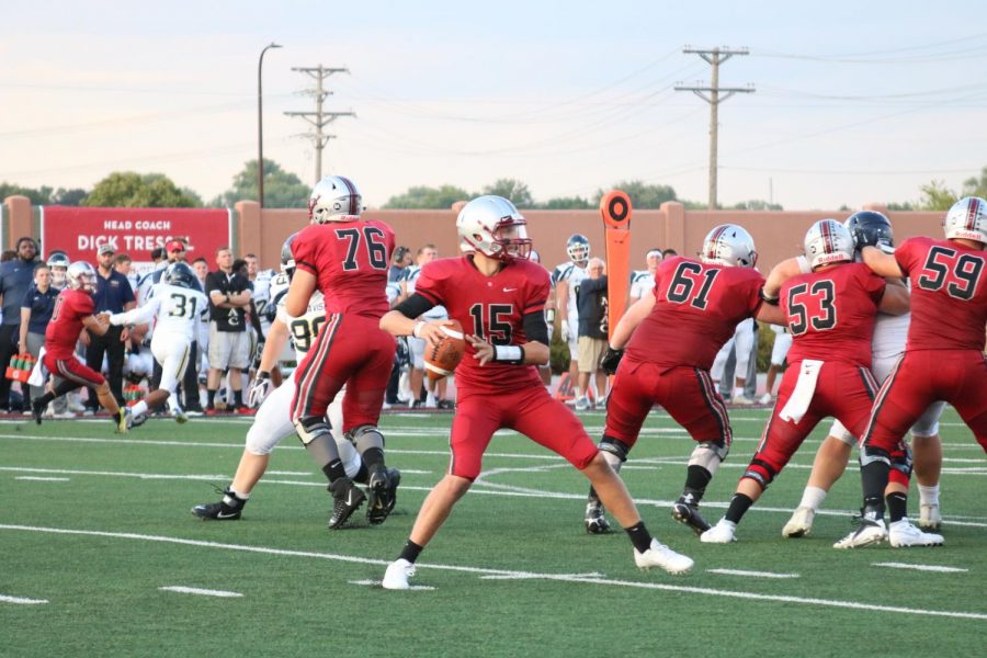 Junior quarterback Connor Leavens (#15) readies to pass as his offensive line holds the defense back.