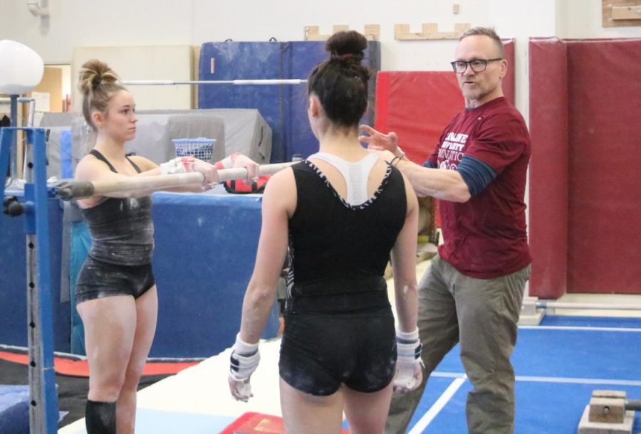 Coach+Doug+Byrnes+talks+with+sophmores+Savannah+Tafolla+and+Katie+Viles+before+starting+to+work+on+some+uneven+bars+elements.