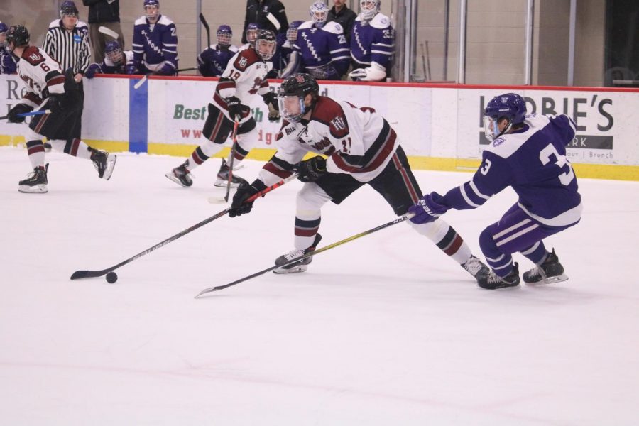 Senior and Mens Hockey Captain Brady Crabtree reaches for the puck in a Feb. 15 match against St. Thomas. This was Crabtrees last game as a student athlete. 