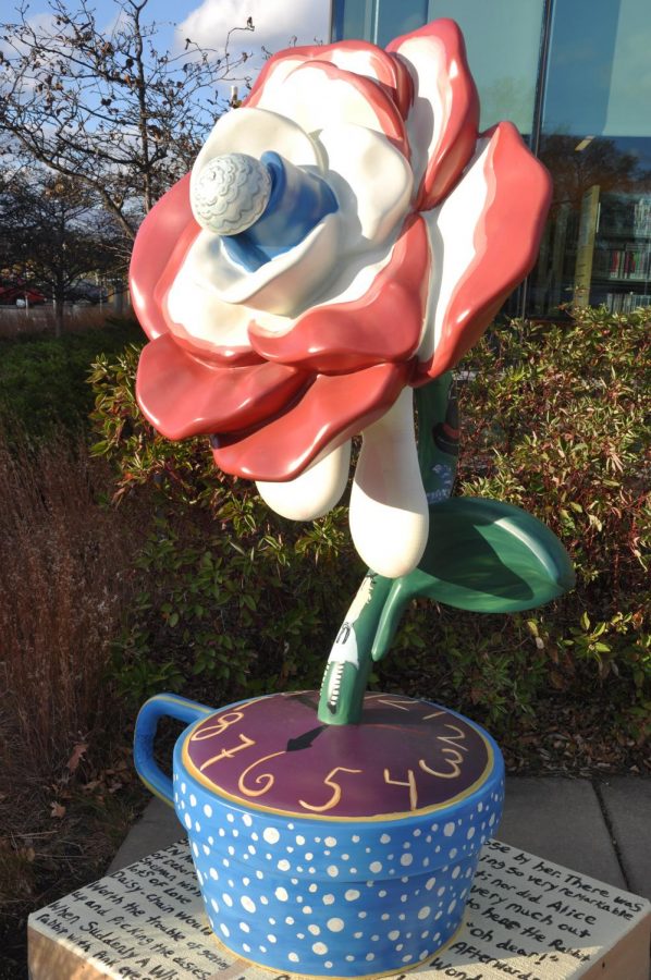 Rose statue with red and white petals placed in front of library winddow