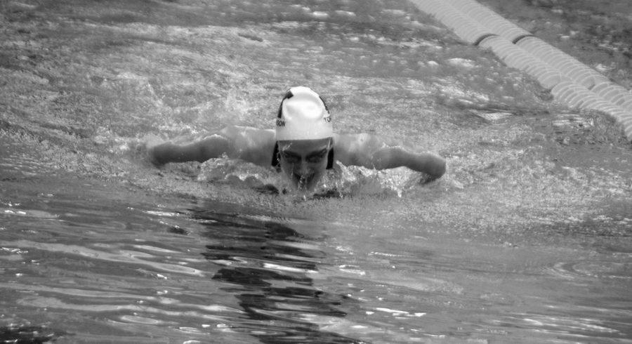 A member of the womens swim team doing the butterfly