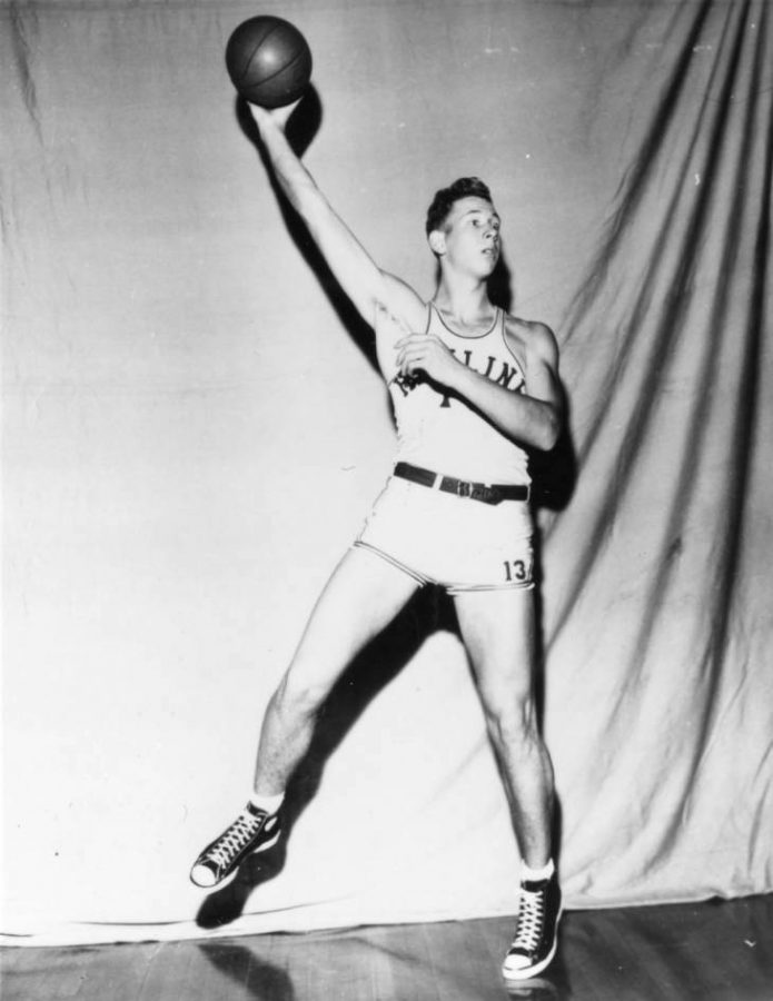 Black and white photograph of Hamline basketball player holding a basketball in this hand