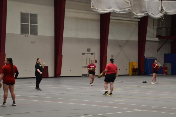 Softball players warm up with a game of catch inside Walker Fieldhouse during a break in the regular season, which will resume on April 3 versus Bethel.