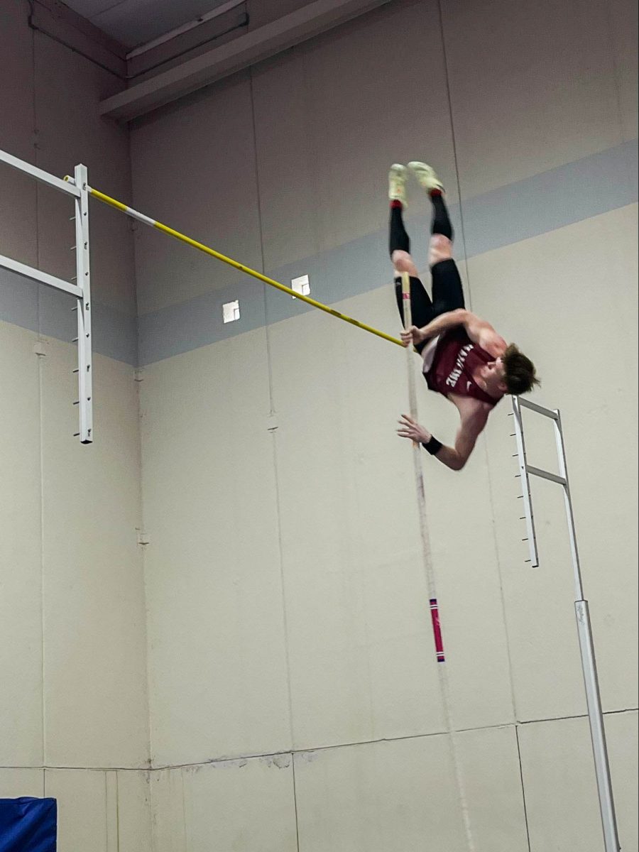 Jumper Austin Schroeder lunges up and over the bar at the Luther invitational.