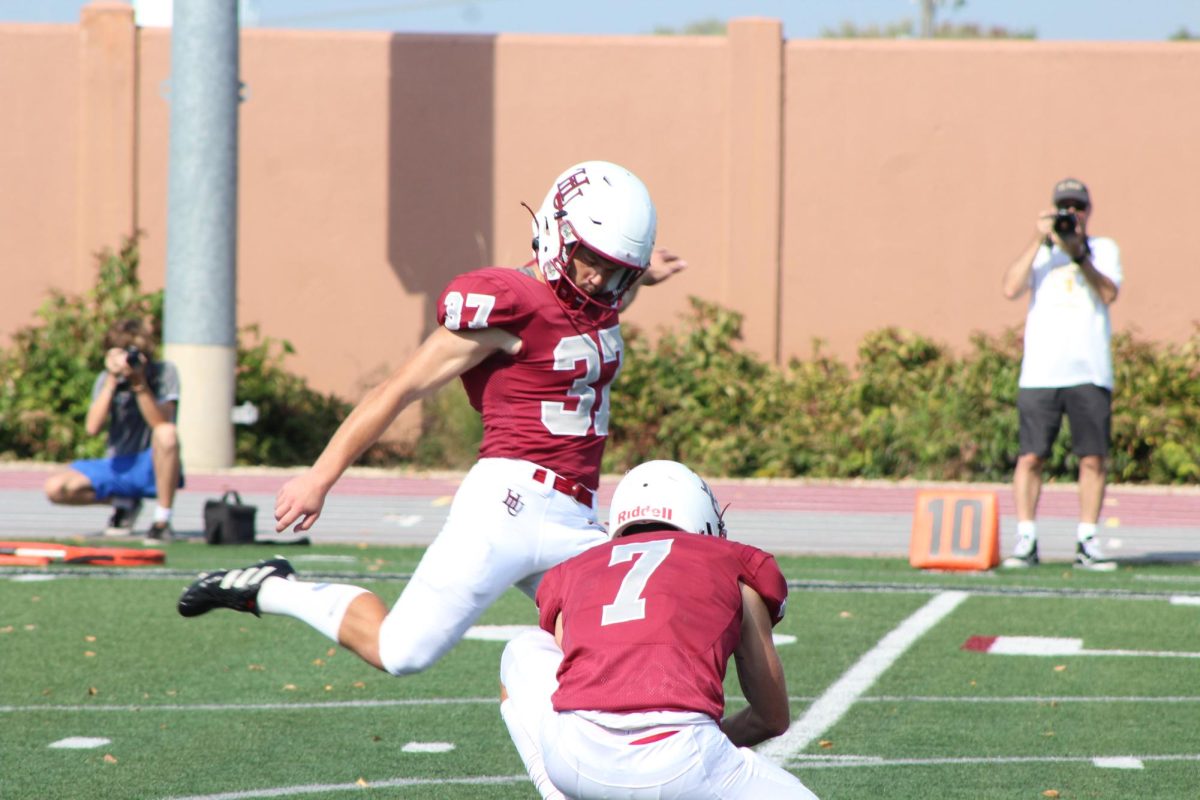 Linebacker and junior (right) Elijah Gingras holds the football steady for Kicker and Hamline class 25’ (left) Durham Welch to make a field goal, earning another point for the Pipers during their 24’-25’ season.