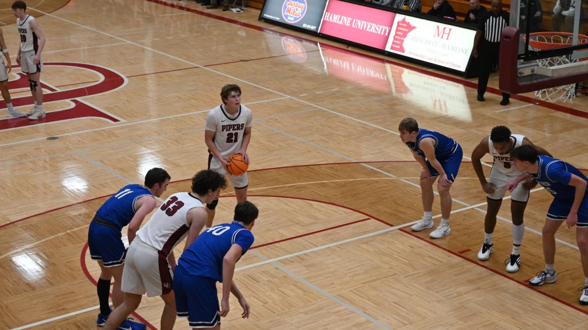 Brendan Ebel (#21) prepares to make a free throw shot as players #33 Dominic Dosmann & #5 Ethan Wall-Atim prepare to defend the ball.