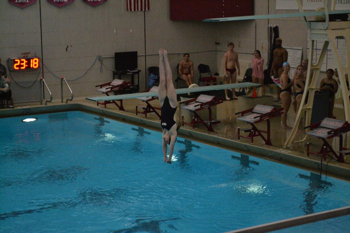 Concordia-St. Paul student taking a dive from 3m, other participants of the meet are in the background.